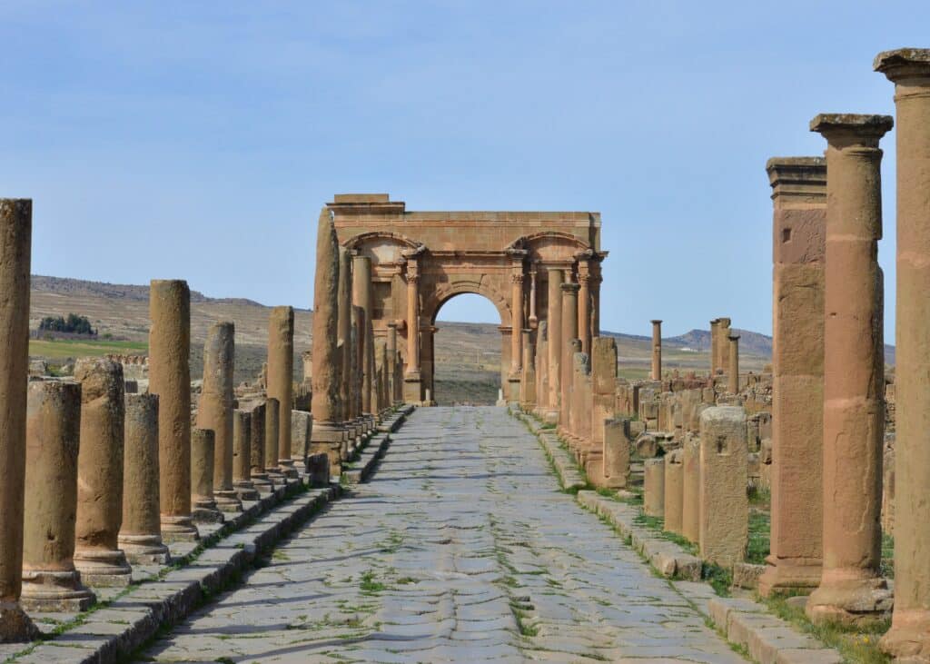 Imagens das ruinas de Batna na Argélia durante o dia com várias colunas deterioradas.