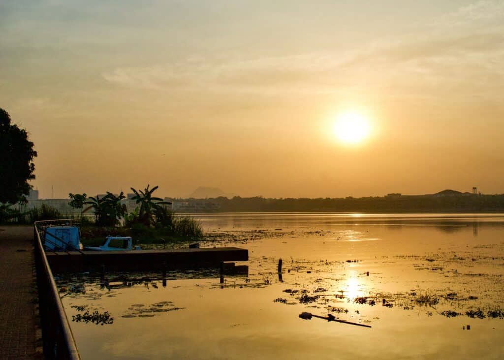 Pôr do sol em Abuja, Nigéria com um rio a frente.
