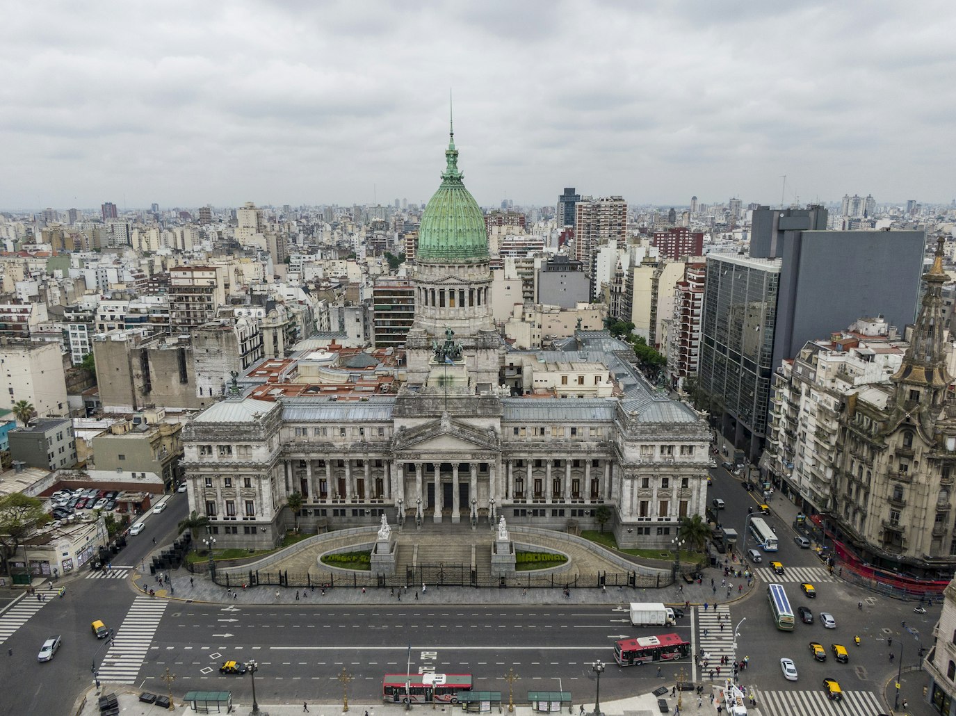 Vista aérea de um grande edifício governamental em Bueno Aires neoclássico com uma cúpula verde, cercado por uma paisagem urbana e ruas movimentadas. Representa eSIM Buenos Aires.