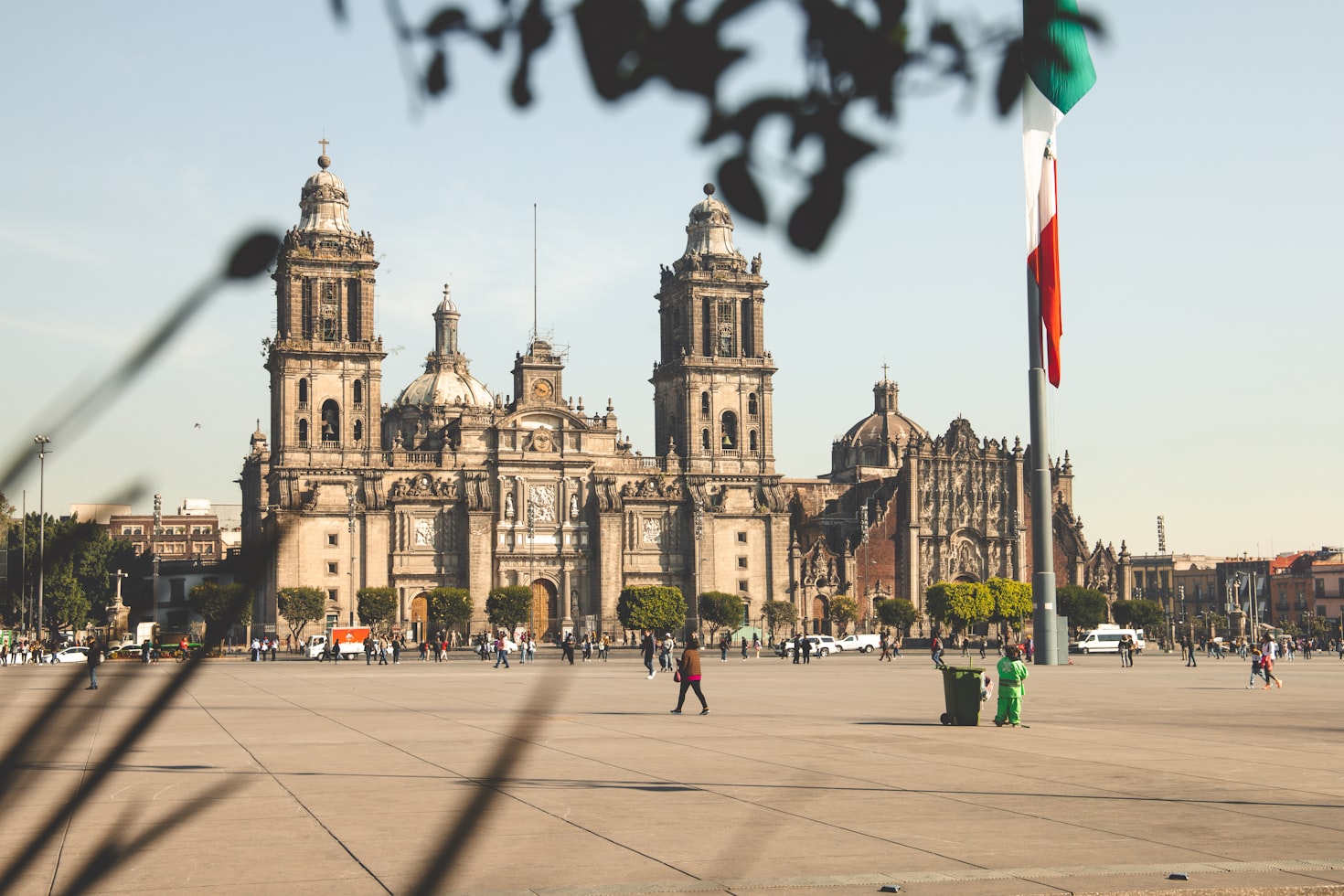Uma catedral histórica na Cidade do México com uma grande praça na frente. Pessoas estão caminhando, e parte de uma bandeira é visível à direita. Representa eSIM México.