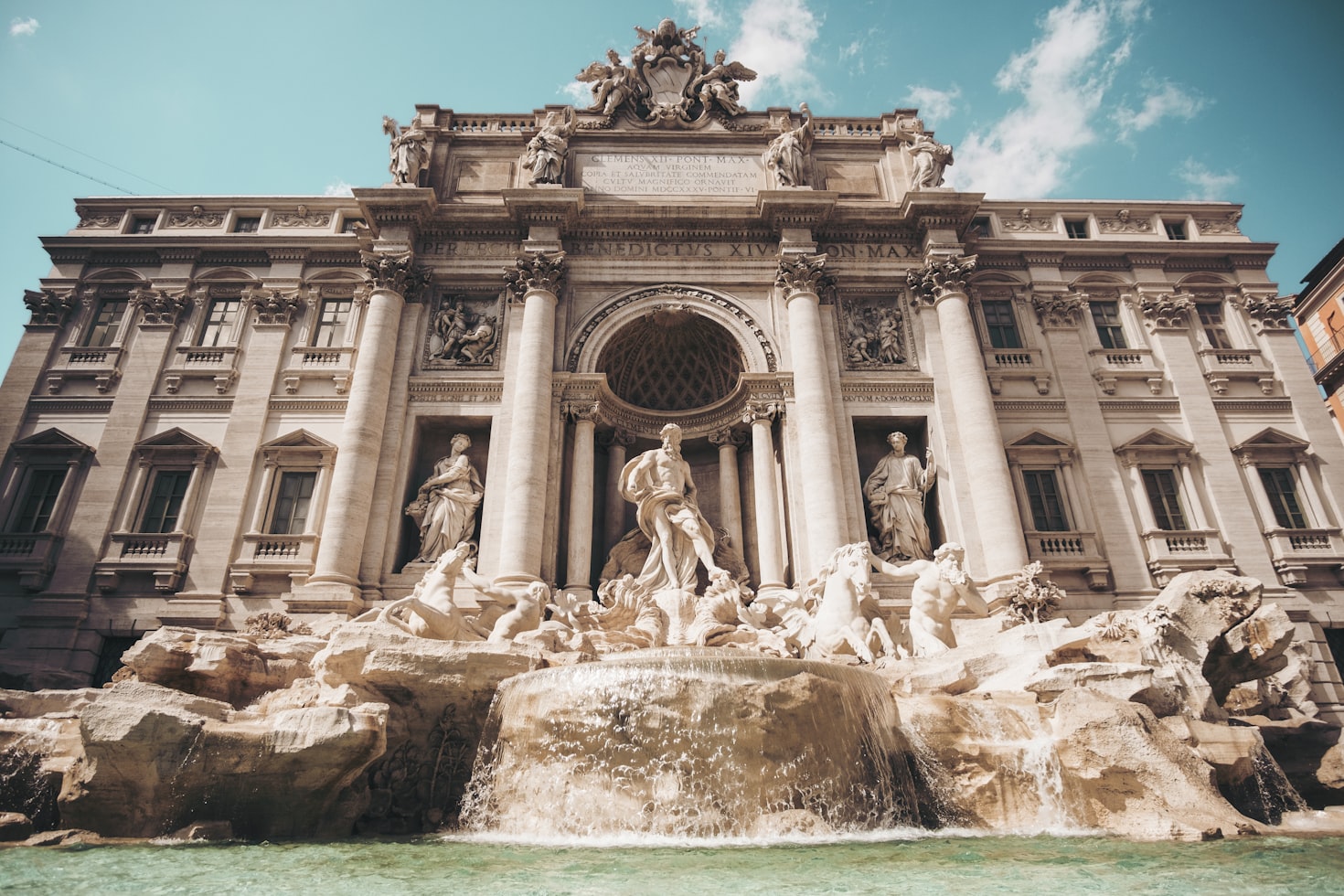 A Fontana di Trevi em Roma, Itália, com esculturas elaboradas e água corrente sob um céu azul claro. Representa eSIM Roma.
