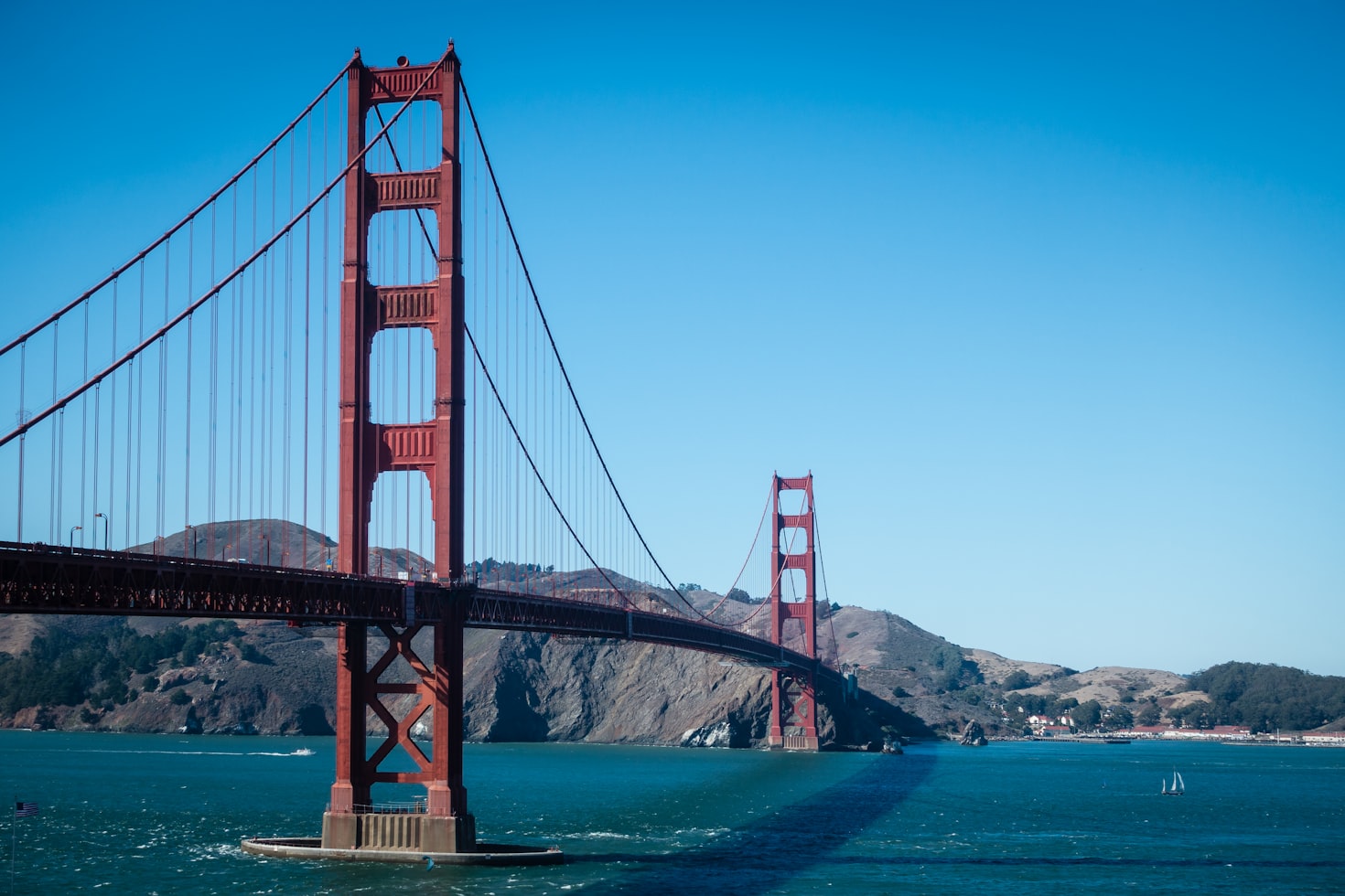 A Ponte Golden Gate se estende sobre águas azuis, com colinas e um céu claro ao fundo. Representa eSIM San Francisco.