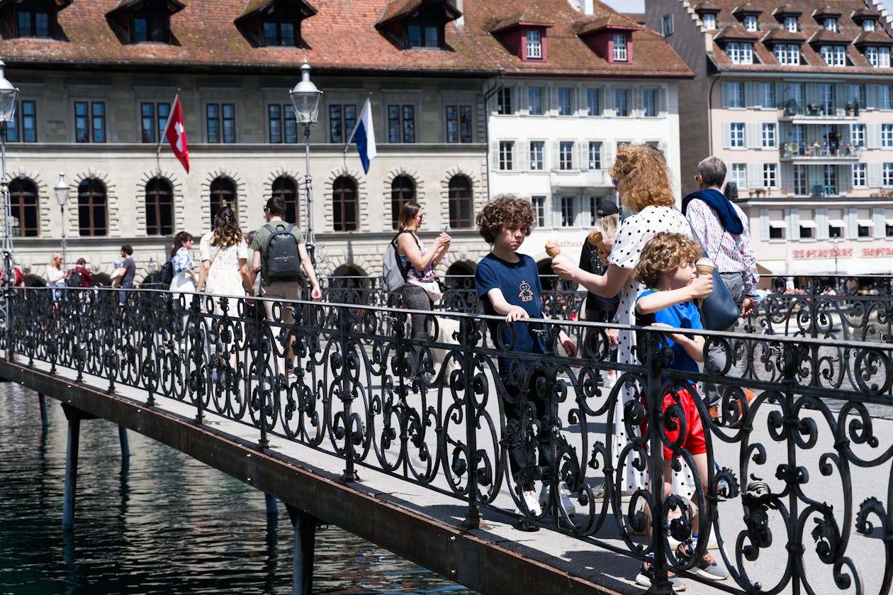 Pessoas aproveitando dia ensolarado na Ponte da Capela em Lucerna Suica representando viagem segura pela Europa com seguro viagem Chubb
